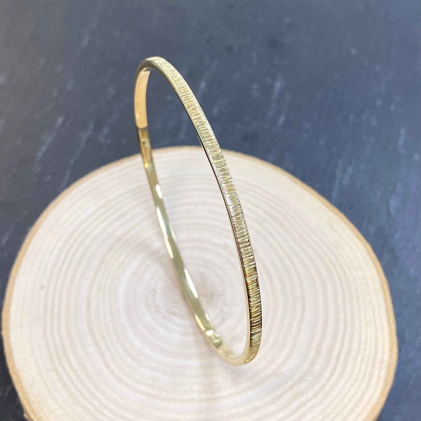 Gold bangle with circle 2025 and line through it